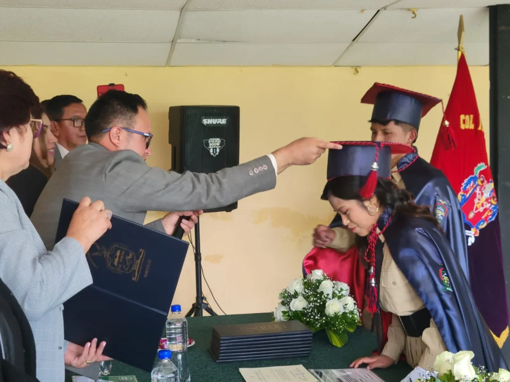 Estudiante con cáncer es la mejor egresada de su colegio. El Ms. José Luis Guerrero, rector de la UE ‘Puruhá’, impone el birrete a la mejor de la promoción: Nicole