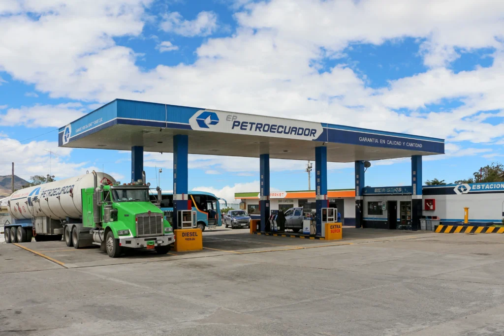 Despidos en Petroecuador: Estación de servicio Petroecuador atendiendo a vehículos, la cara pública de la empresa estatal en medio del anuncio de despidos y reestructuración.